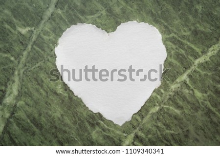 Heart shaped white sheet of paper on a faded marble background for love notes