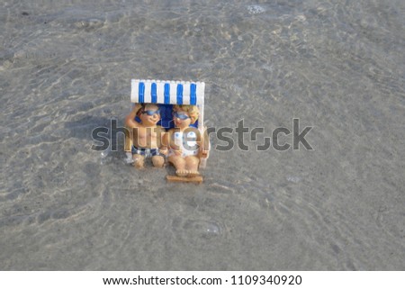 Tourist couple makes beach holidays. Happy smiling couple sits with the feets in water in a beach chair.