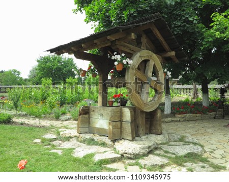 Vintage old wooden water well with huge giant wheel