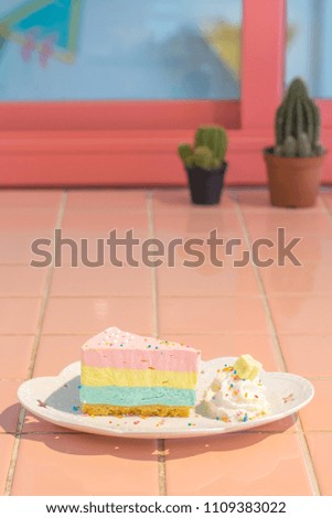 Summer Rainbow Cheesecake isolated in white plate on the cute colourful table and pretty background with copy space.