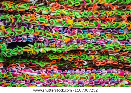 The colorful wraps are stacked and waiting to be picked up by the people, because they are good to use and are popular in Thailand because they are cheap.
Checkered fabric background stacked up.