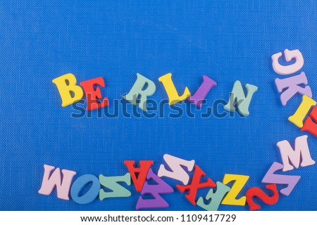 BERLIN word on blue background composed from colorful abc alphabet block wooden letters, copy space for ad text. Learning english concept