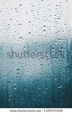 Raindrops on the window glass, blue background
