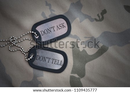 army blank, dog tag with text dont ask dont tell on the khaki texture background. military concept
