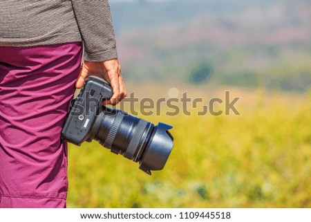 Photographer holds her DSLR camera in her right hand