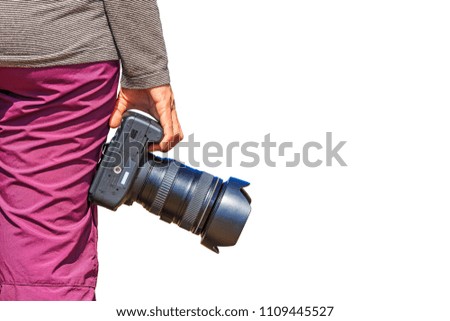 Photographer holds her DSLR camera in her right hand, isolated on white background with clipping path