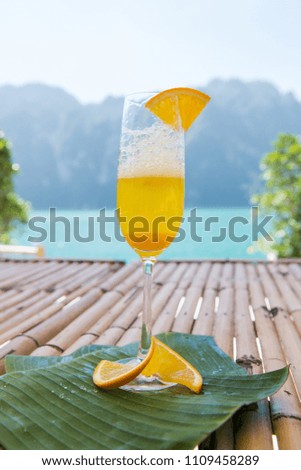 A glass of italian soda drink on the table. Fresh drink with yellow lemon in colorful soda. Summer drink in sunny day
