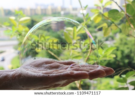 Soapsuds on palm. Bubble in hand.