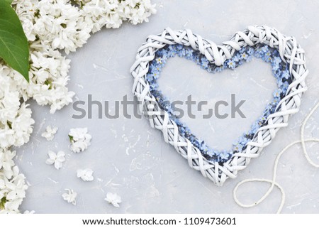 Close-up photo of white flowers heart shape on gray table background. Concept for a wedding, betrothal, engagement, Valentine's day, mother's day. Top view
