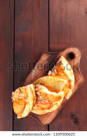 Homemade pizza on a wooden board, sliced pizza on a wooden background in rustic style, sandwiches with meat and cheese top view, delicious fast food at home kitchen, American cuisine, copy space