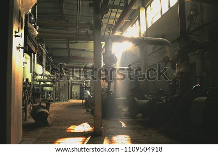 abandoned factory building, with barrels and equipment, vintage and atmospheric, a lot of pipes, cables, oil production, a ray of light