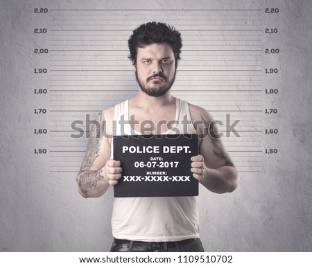 Caught gangster in jail with table on his hand. Royalty-Free Stock Photo #1109510702
