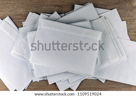 Outgoing correspondence: few empty white envelopes on a wooden desk in the office, enhanced contrast
