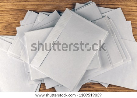 Outgoing correspondence: few empty white envelopes on a wooden desk in the office, enhanced contrast