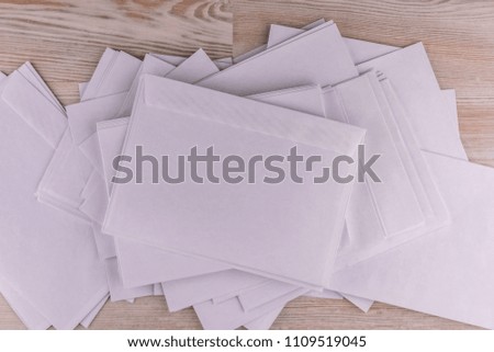 outgoing correspondence: few empty white envelopes on a wooden desk in the office, low contrast