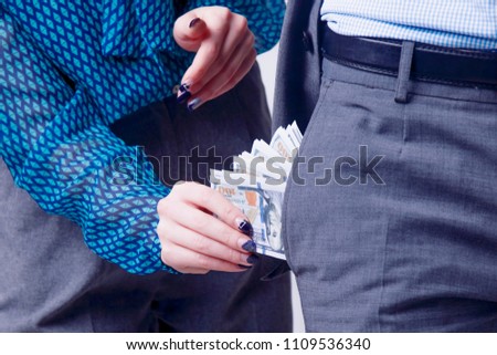 Woman takes money from her husband.  Concept picture. (Gender inequality, wealth, family budget concept)