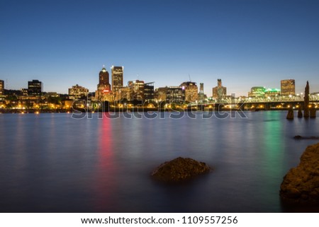 City Skyline and waterfront at night with river in foreground