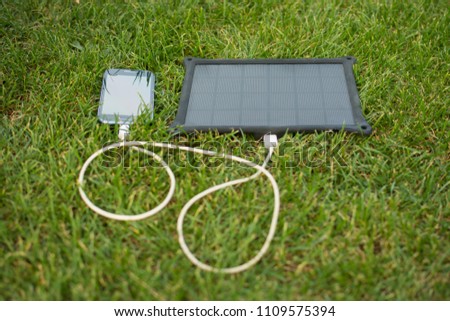 Use of renewable energy - Mobile Phone Chargers on grass in nature with Sun