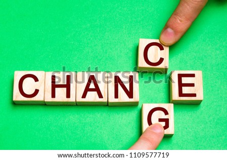 Wooden blocks with letters and words change and chance. The concept of self-motivation, self-development and improvement of personal qualities. Fingers place letters to change the word.