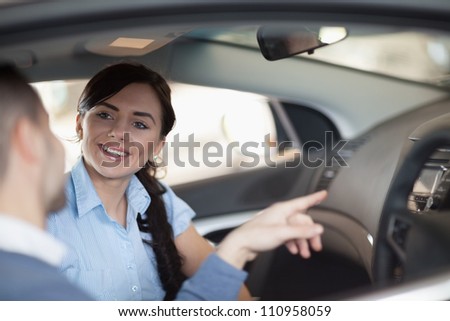 Man pointing a car interior while sitting in a car