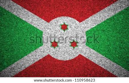 The Burundi flag painted on a cork board.
