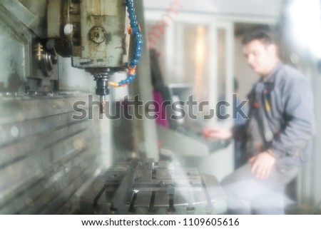 Metal worker working on CNC machine