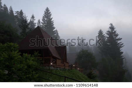 Wooden house on foggy mountain at morning