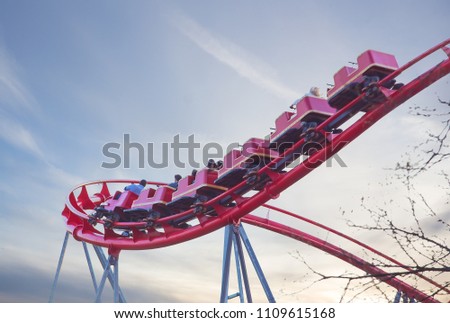 people on the roller coaster ride on the cloud sky background