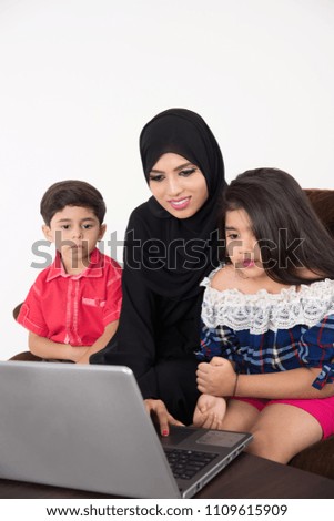Arab woman teaching her children using laptop computer on white background
