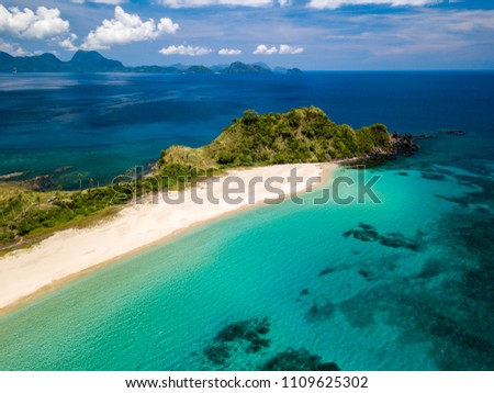 Aerial drone view of an empty, beautiful tropical beach surrounded by coral reef and greenery (Nacpan Beach, Palawan) Royalty-Free Stock Photo #1109625302