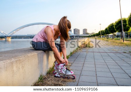 Girl unrecognizable, putting on and adjusting roller skates 