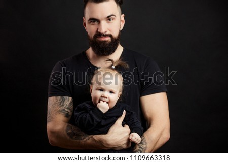 Portrait of masculine adult man with strong body in perfect fit with baby on hands . Loving Father holding and taking care of adorable toddler daugter.