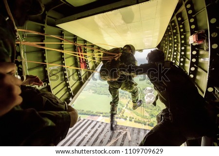 Rangers parachuted from military airplanes, Soldiers parachuted from the plane, isolated airborne soldier, practice parachuting, Paratroopers jumping from an airplane. Royalty-Free Stock Photo #1109709629