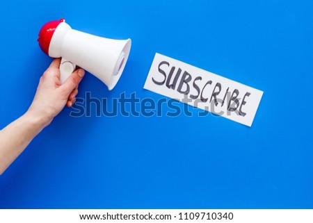 Subscribe template or mockup. Hand lettering subcribe near megaphone on blue background top view space for text
