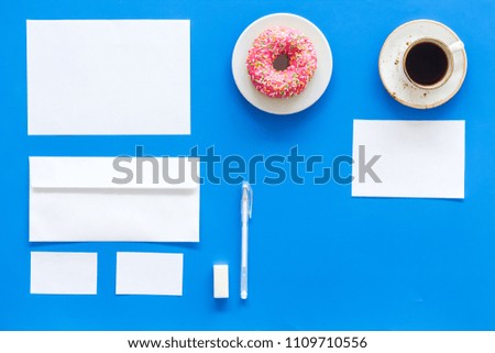 Come up with brand identity. Blank stationery for branding near coffee and donut on blue background top view mockup pattern copy space