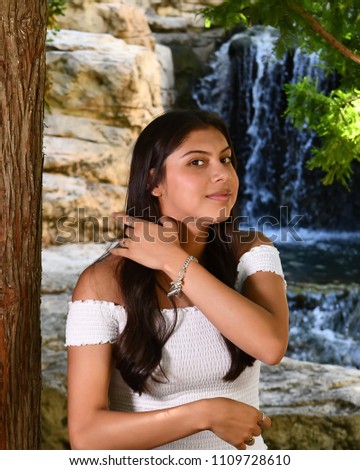 Young Female High School Senior posing for Senior photos in a beautiful park setting
