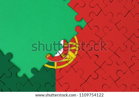 Portugal flag  is depicted on a completed jigsaw puzzle with free green copy space on the left side