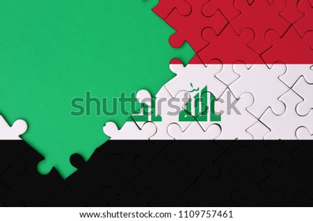 Iraq flag  is depicted on a completed jigsaw puzzle with free green copy space on the left side
