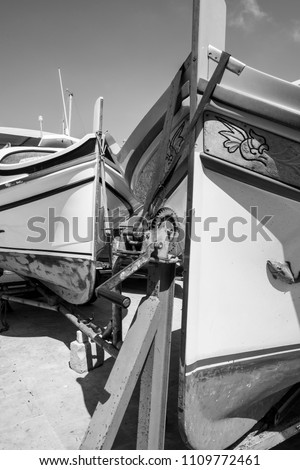 Yachts docked at the port of Malta. Boats on the trolley for launching on the water. Black and white picture