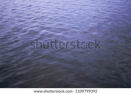Blue abstract background. Waves on the water. Smooth surface.
