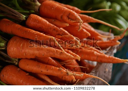 Fresh local organic carrots for sale at a local farmers market. Market stall with variety of organic vegetable. Selective focus.
