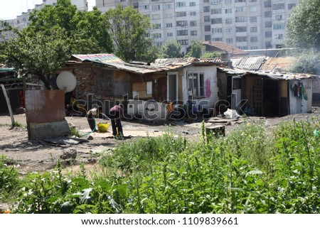 Unrecognizable gypsies. Misarable gypsy hovels surrounded by junk. Gipsy ghetto right below living buildings in Sofia, Bulgaria. Romany, rom or tsigani. Global plastic pollution.  place to live.  Royalty-Free Stock Photo #1109839661