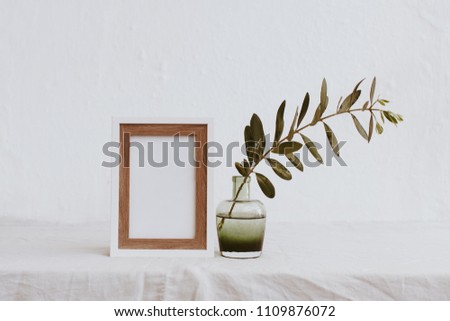 White frame mockup, olive branch in glass bottle, pitcher, styled minimalist clean image for product marketing, social media, blogging