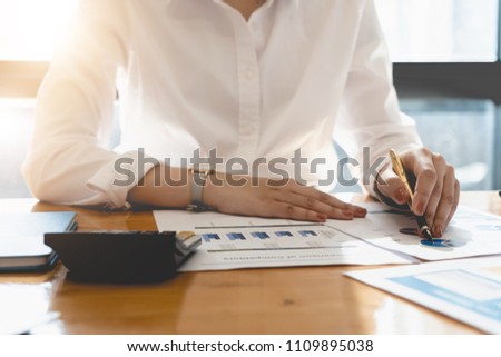 Business woman investment consultant analyzing company annual financial report balance sheet statement working with documents graphs. Concept picture of business, market, office, tax.