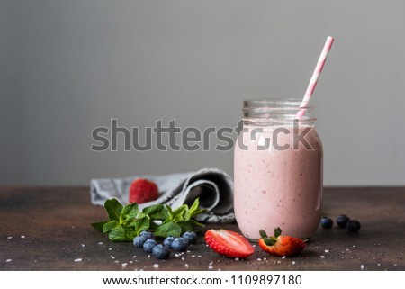 Strawberry smoothie in a jar on gray background. Concept of healthy lifestyle, healthy eating, summer drinks and vegan food. Toned image