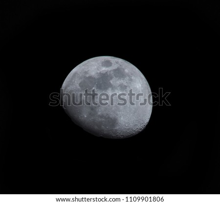 the moon in a near complete form at the  center of the picture.