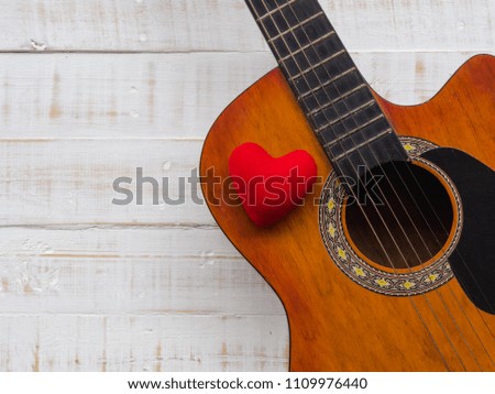 The guitar and red heart on white wooden texture background. Love, Music day concept.