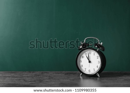Alarm clock on table against color background. Time concept