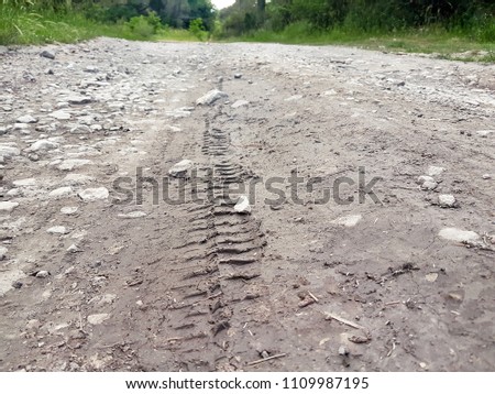 Bike, tractor, excavator, car, automotive tire tracks on muddy trail. Mud and wheel trace on road after rain. Mud with truck wheel track in rainy day. Background, texture, material, wallpaper.