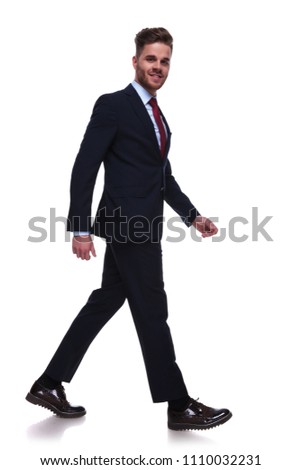 businessman in navy suit and red tie stepping to side on white background, full body picture